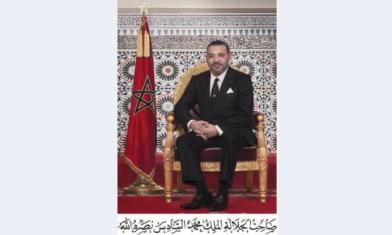 Portrait officiel du roi Mohammed VI du Maroc, assis sur un trône doré, à côté du drapeau marocain